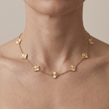 A gold-plated station necklace worn at the collarbone